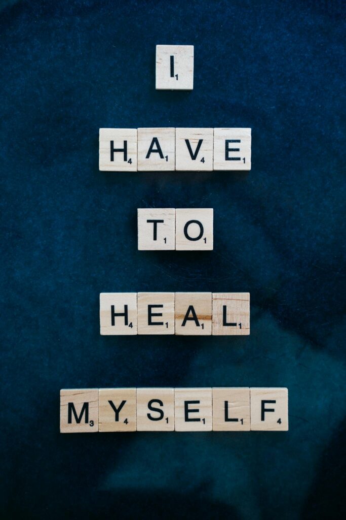 Scrabble tiles forming 'I Have to Heal Myself' on a dark blue backdrop, promoting self-awareness.